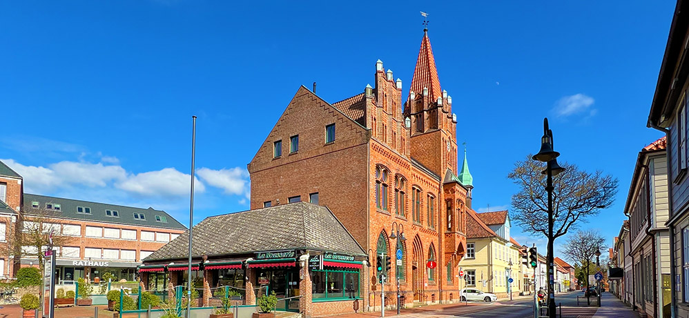 Eine andere Ansicht des alten Rathauses mit dem neuen Rathaus links im Bild. Es ist der Rathausplatz zu erkennen und die kleine Brasserie.